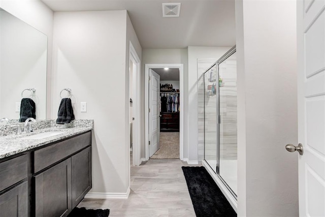 bathroom featuring vanity, wood-type flooring, and walk in shower