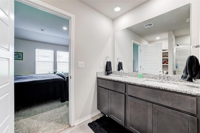 bathroom featuring vanity, hardwood / wood-style floors, and a shower with shower door