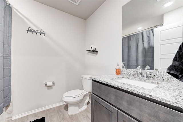 bathroom featuring wood-type flooring, toilet, and vanity