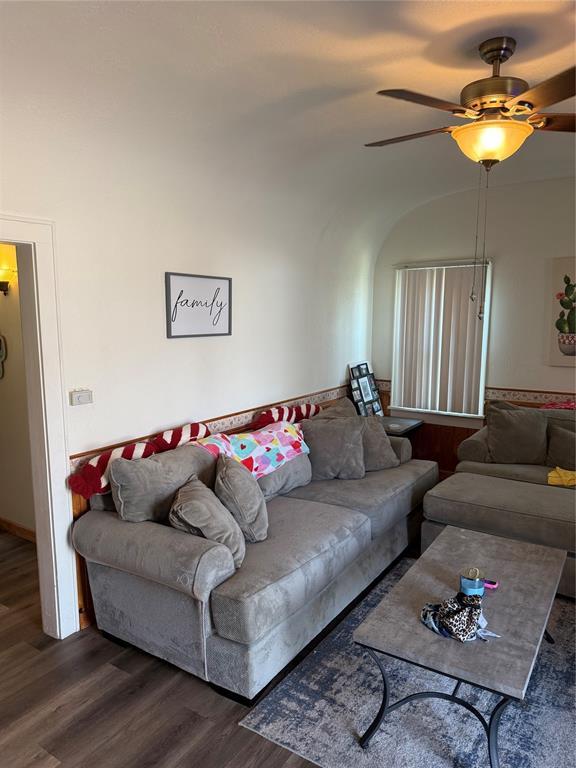 living area with wood finished floors and a ceiling fan