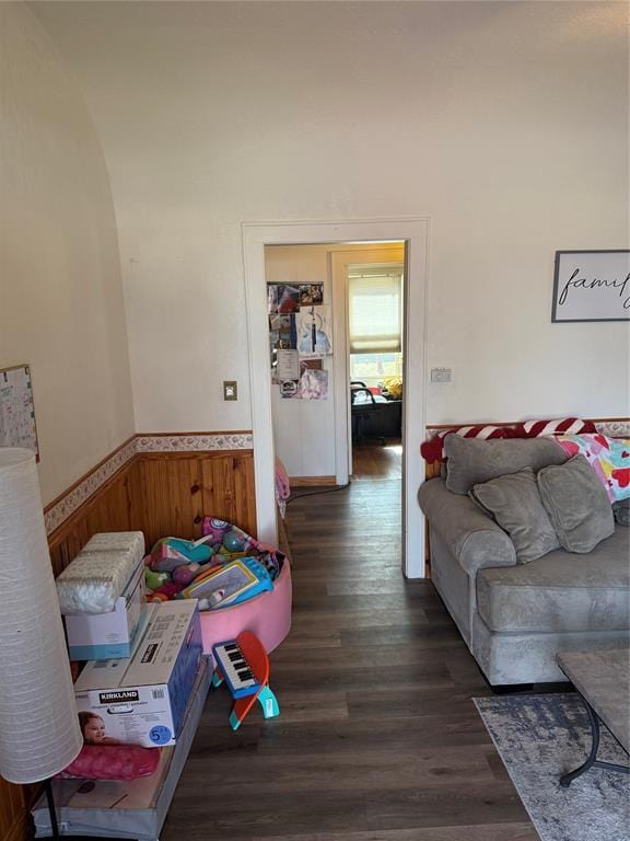 living area featuring a wainscoted wall, wooden walls, and wood finished floors