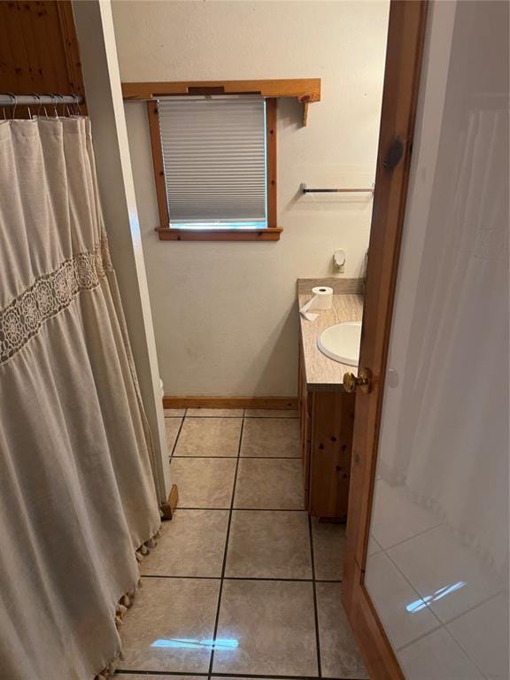 full bathroom with a shower with curtain, tile patterned flooring, baseboards, and vanity