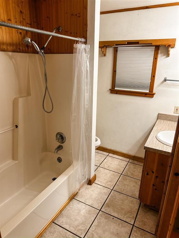 314 W Kentucky Ave, Anadarko, OK 73005 - full bathroom featuring shower / bath combo with shower curtain, vanity, and tile patterned flooring