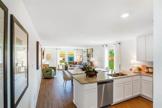 kitchen featuring white cabinetry, stainless steel dishwasher, plenty of natural light, and kitchen peninsula