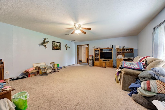 living room with ceiling fan, carpet floors, and a textured ceiling