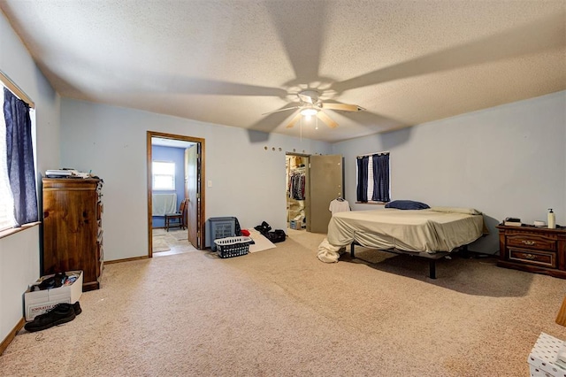 bedroom with a closet, ceiling fan, light carpet, and a textured ceiling