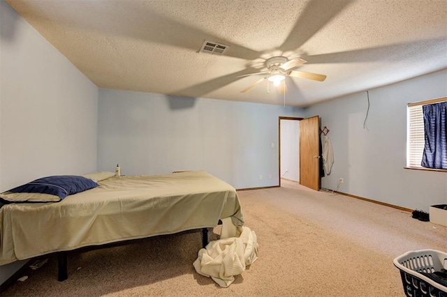 carpeted bedroom featuring ceiling fan and a textured ceiling