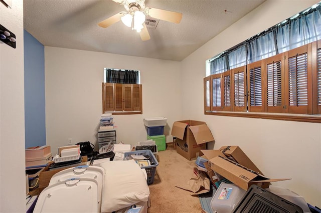 miscellaneous room featuring ceiling fan, carpet floors, and a textured ceiling