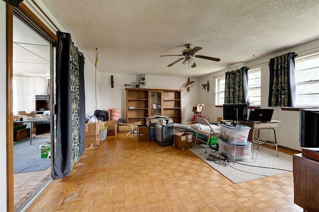 interior space with ceiling fan, light parquet flooring, and a textured ceiling