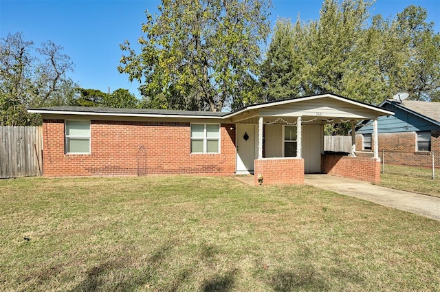 ranch-style home featuring a front lawn and a carport