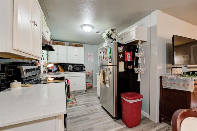 kitchen with white cabinetry, light hardwood / wood-style flooring, a textured ceiling, and appliances with stainless steel finishes