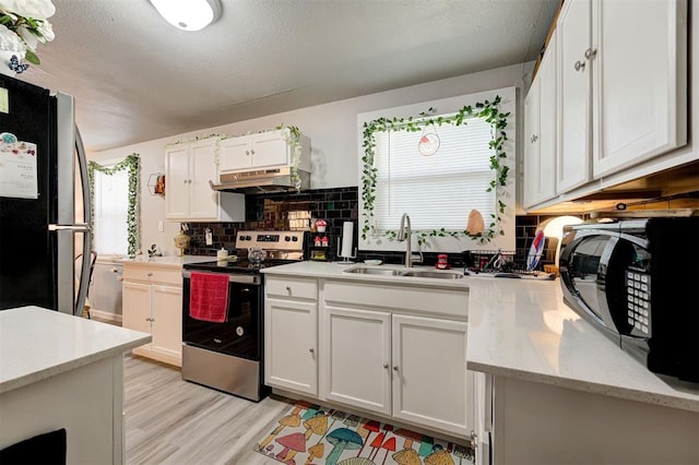 kitchen featuring white cabinetry, sink, backsplash, and appliances with stainless steel finishes