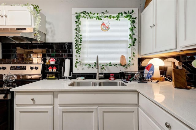 kitchen with white cabinetry, backsplash, sink, and electric range