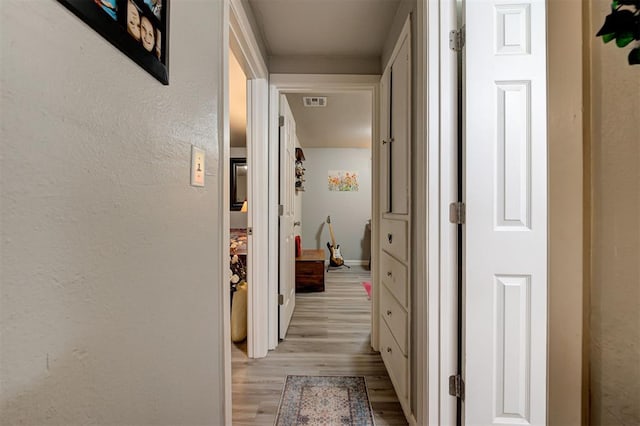 hallway with light hardwood / wood-style floors