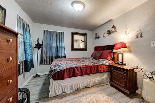 bedroom featuring a textured ceiling and light wood-type flooring