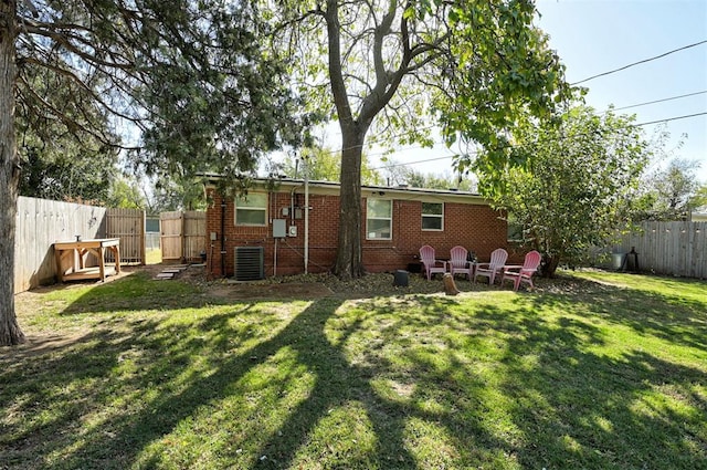 back of house featuring a yard and central AC unit