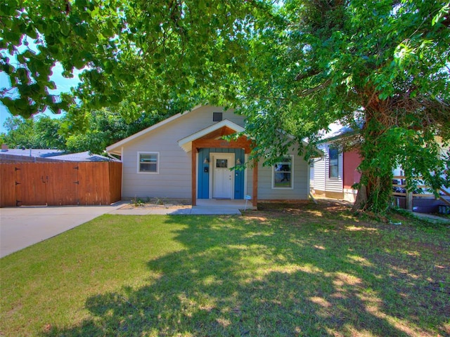 view of front of property featuring a gate, fence, and a front lawn