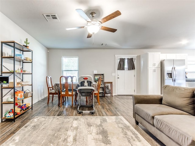 living room featuring ceiling fan, dark wood-style flooring, and visible vents