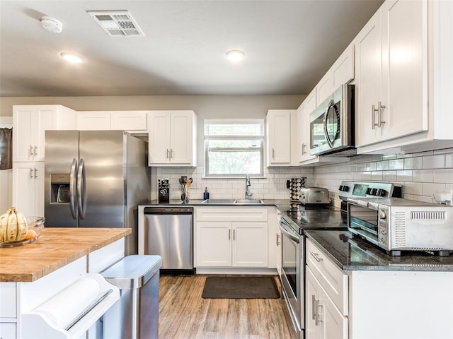 kitchen featuring white cabinetry, visible vents, and stainless steel appliances