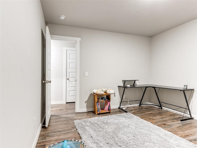 bedroom with baseboards and wood finished floors