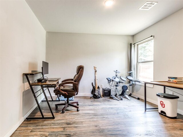 home office featuring visible vents, baseboards, and wood finished floors