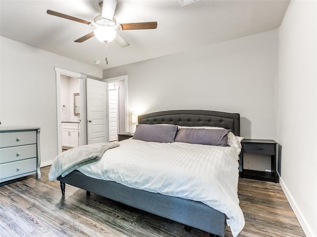 bedroom featuring a ceiling fan, ensuite bathroom, baseboards, and wood finished floors