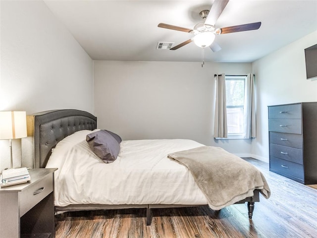 bedroom with visible vents, ceiling fan, baseboards, and wood finished floors