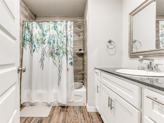 full bath featuring shower / tub combo with curtain, vanity, and wood finished floors