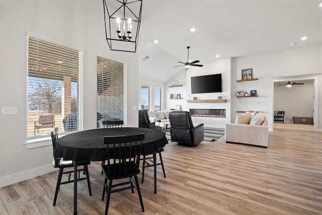 dining space featuring ceiling fan, high vaulted ceiling, and light wood-type flooring