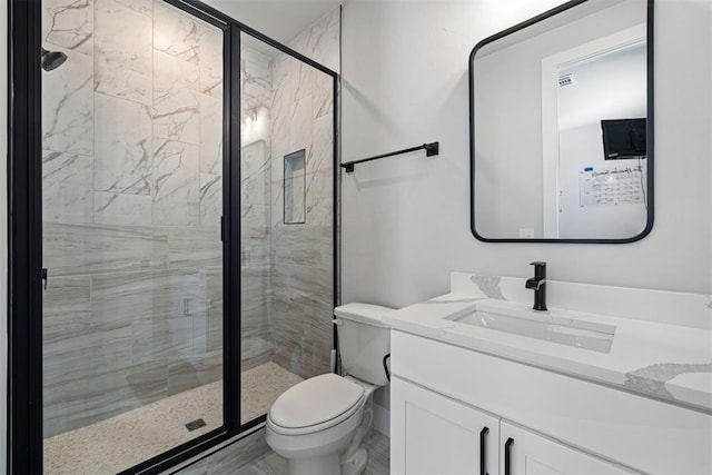 bathroom with vanity, a shower with shower door, and toilet