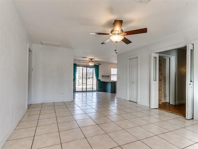 unfurnished room featuring ceiling fan and light tile patterned floors