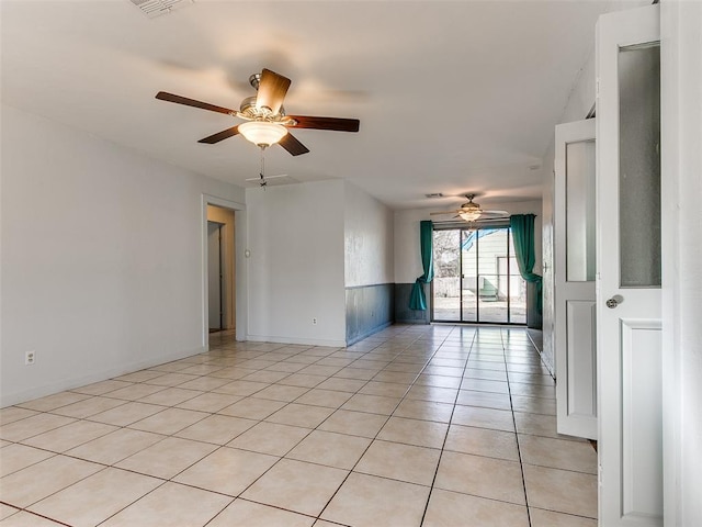 tiled spare room with ceiling fan