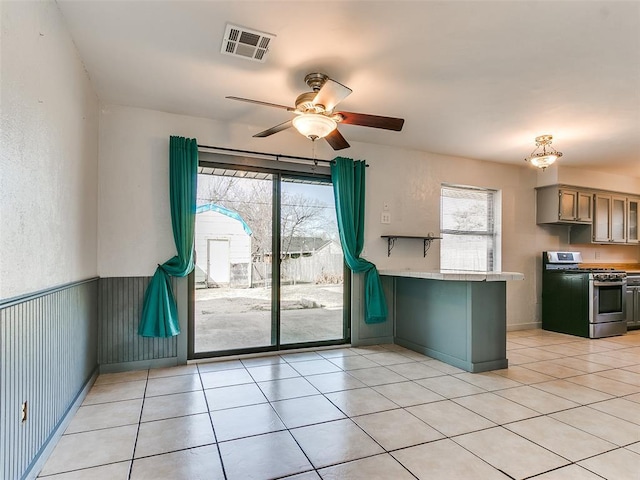 kitchen featuring stainless steel range with gas stovetop, light tile patterned floors, and a wealth of natural light