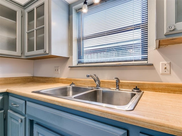 kitchen featuring sink, blue cabinetry, and a healthy amount of sunlight