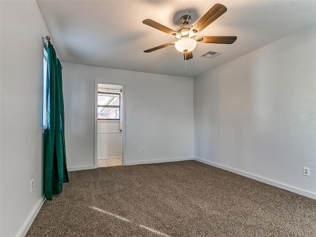 unfurnished room featuring a textured ceiling, light colored carpet, and ceiling fan