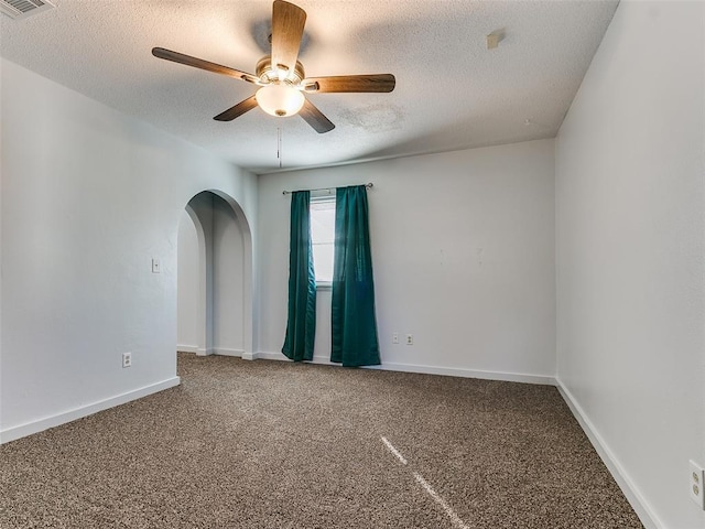 empty room with ceiling fan, a textured ceiling, and carpet