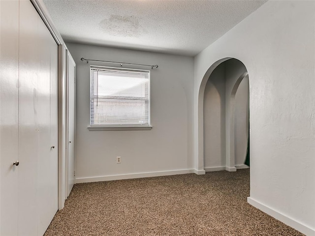 carpeted spare room with a textured ceiling