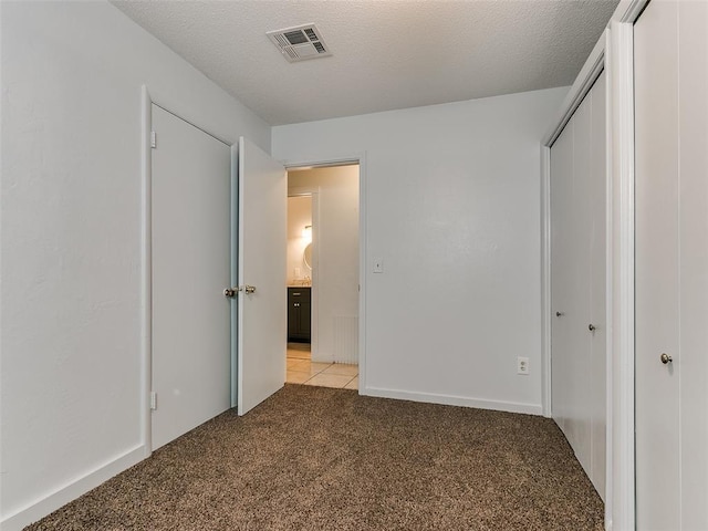 unfurnished bedroom with light carpet and a textured ceiling