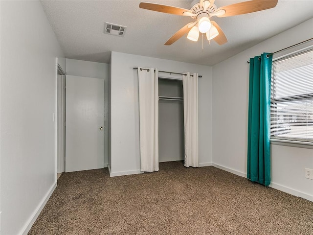 unfurnished bedroom featuring ceiling fan, a closet, and carpet