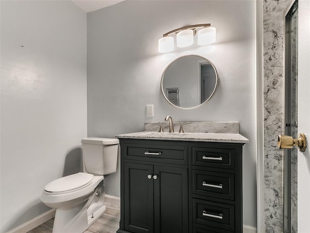 bathroom featuring vanity, hardwood / wood-style floors, and toilet