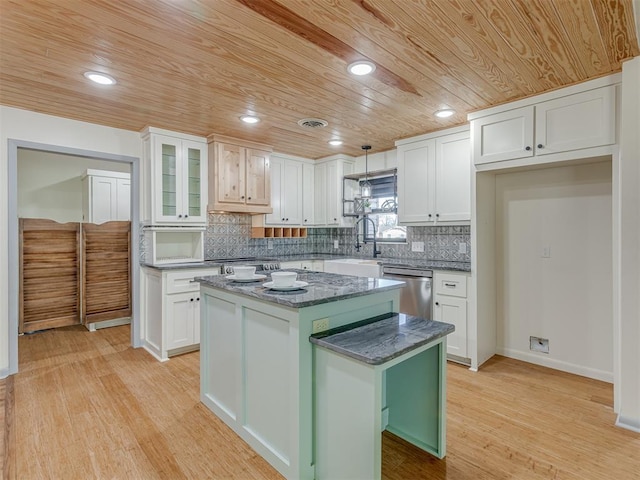 kitchen with white cabinetry, sink, stainless steel dishwasher, and a center island