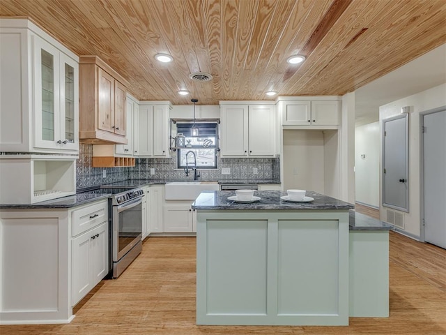 kitchen featuring white cabinetry, stainless steel electric range oven, a center island, and sink