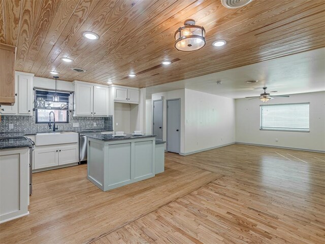 kitchen featuring a healthy amount of sunlight, sink, a center island, and white cabinets