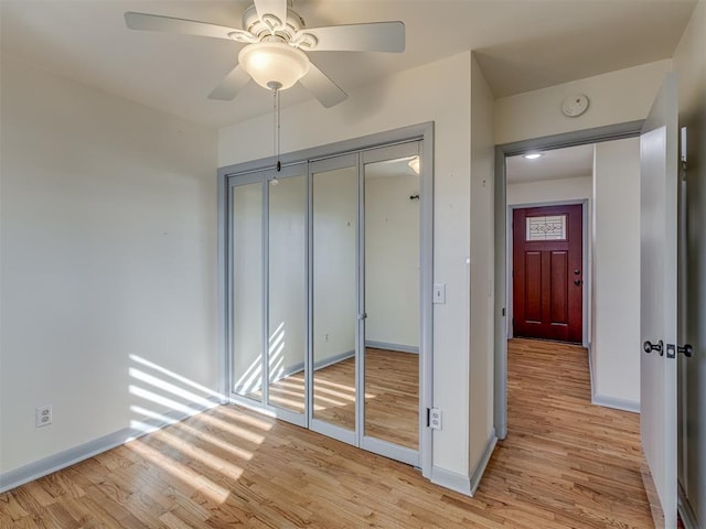 unfurnished bedroom with ceiling fan, light hardwood / wood-style floors, and a closet