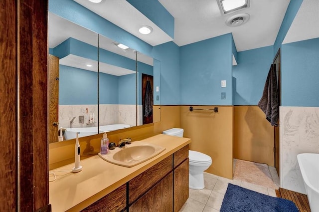 bathroom with a tub to relax in, toilet, tile patterned flooring, and vanity