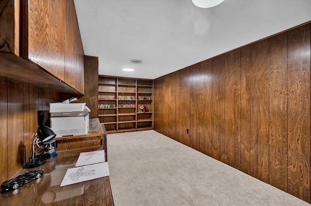 office with carpet floors, built in features, and wooden walls