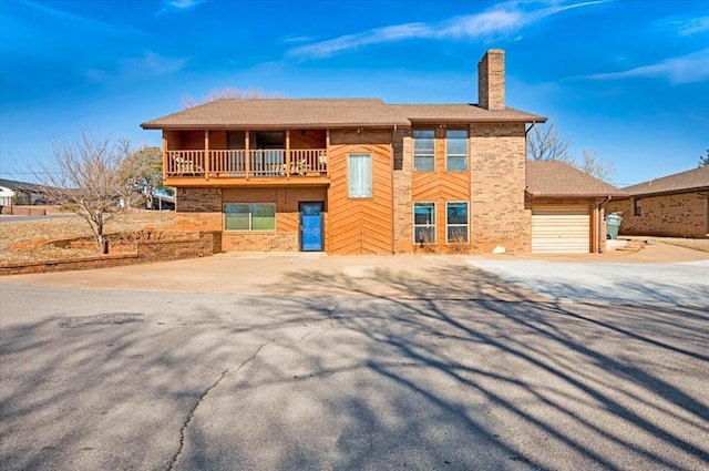 view of front of home with a garage and a balcony