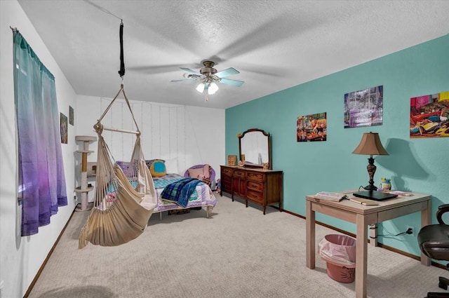 carpeted bedroom featuring ceiling fan and a textured ceiling