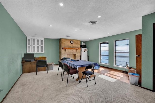 playroom with light carpet, a fireplace, and a textured ceiling