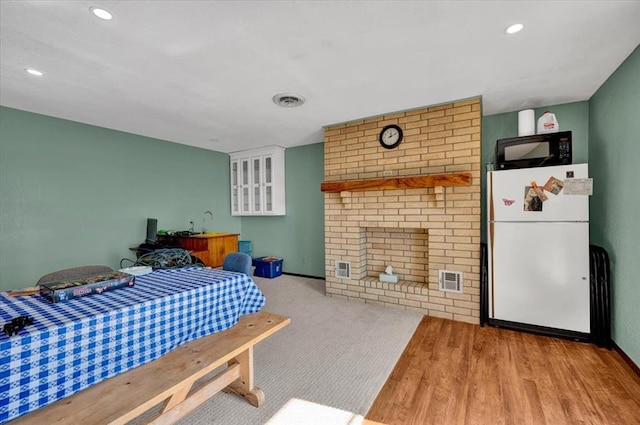 bedroom with white refrigerator and light wood-type flooring